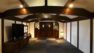 a hallway with a door and a tv in a room at 別邸 六花 in Hino