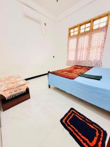 a bedroom with a bed and a rug on the floor at Dew homestay in Wellawaya