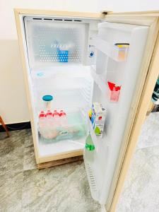 an open refrigerator filled with water and milk at Dew homestay in Wellawaya