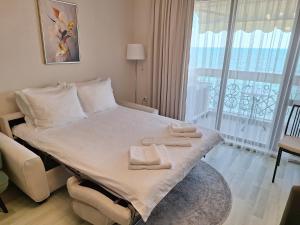 a hotel room with a bed with towels on it at Apartment Maraya 2, Carpe Diem complex, Balchik, free parking in Balchik