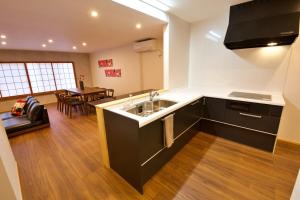 a kitchen with a sink and a living room at OKU - Nakasendo - in Shiojiri