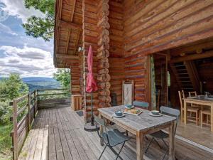 a wooden deck with a table and chairs on a cabin at Chalet rustique avec poêle à bois - 3 pers, animaux admis - FR-1-496-187 in Saint-Martin-la-Sauveté