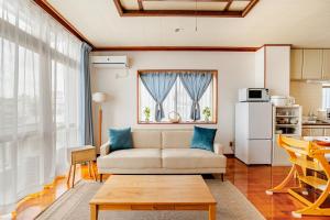 a living room with a couch and a table at Rela More in Ginowan