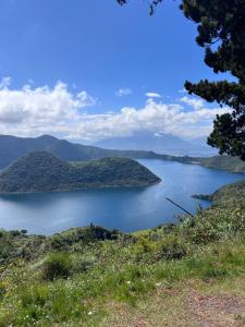 a view of a lake with mountains in the background at Refugio del venado Cuicocha in Cotacachi