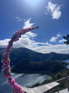 a wreath of flowers on a bench overlooking a lake at Refugio del venado Cuicocha in Cotacachi +12 photos