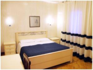 a bedroom with a bed in a room with curtains at Hotel Pisani in Taranto