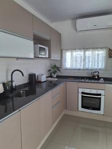 a kitchen with a sink and a stove top oven at La Perla in Nueva Helvecia