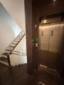 an elevator in a building with a escalator and stairs at Gurukrupa Yatri Nivas in Kolhapur
