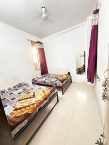 a room with two beds and a hallway at Gurukrupa Yatri Nivas in Kolhapur