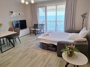 a living room with a bed and a dining room at Apartment Maraya 1 ,Carpe Diem complex, Balchik, free parking in Balchik