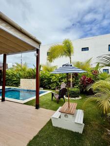 a patio with a table and an umbrella next to a pool at Villa Divina in Punta Cana