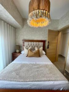a bedroom with a large bed with a chandelier at Villa Divina in Punta Cana +50 photos