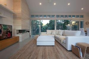 a large living room with a white couch and a tv at White Sands Beach House in Marcoola