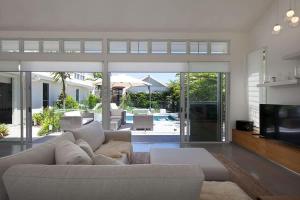 a living room with a white couch and a television at White Sands Beach House in Marcoola +44 photos