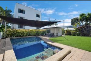 a house with a swimming pool in front of a yard at Apartment on The Strand - 2 Bed 2 Bath in North Ward