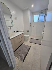 a bathroom with a shower and a sink and a toilet at Apartment on The Strand - 2 Bed 2 Bath in North Ward +17 photos