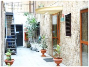 a courtyard with potted plants in front of a building at Hotel Pisani in Taranto