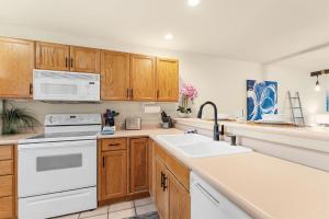 a kitchen with white appliances and wooden cabinets at Emerald Bay Escape with Sunroom in Hollister