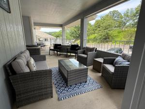 a screened in porch with wicker furniture and a table at Spacious Lakeview Condo with 3 BR3 BA and Pool in Lake Ozark