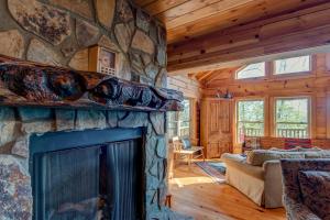 a living room with a stone fireplace in a log cabin at Chestnut Lodge in Boone +40 photos