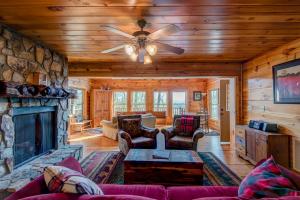 a living room with a fireplace and a ceiling fan at Chestnut Lodge in Boone