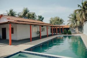 a villa with a swimming pool in front of a house at Aconchego do Peruaçu in Itacarambi