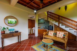 a living room with a staircase and a bench at Umah Dedari in Keramas