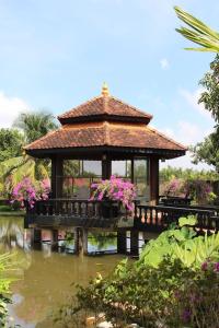 a gazebo in a garden with flowers on a pond at Woods House Homestay in Sa Ðéc