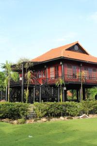 a large house with a balcony and palm trees at Woods House Homestay in Sa Ðéc