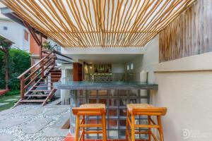 a patio with a bar with two stools at Umah Dedari in Keramas