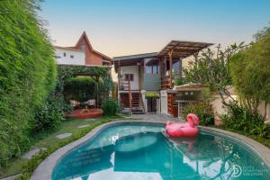 a pool with a pink flamingo in front of a house at Umah Dedari in Keramas