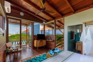 a bedroom with a bed and a desk with a television at Umah Dedari in Keramas