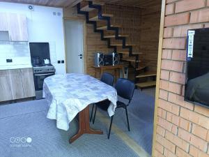 a kitchen with a table and chairs and a staircase at Коттедж Бурабай улица Алатау 38 in Borovoye +16 photos