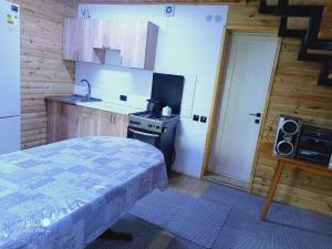 a small kitchen with a bed and a stove at Коттедж Бурабай улица Алатау 38 in Borovoye