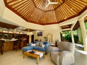 a living room with a blue couch and a wooden ceiling at Bali Emerald Villas in Sanur