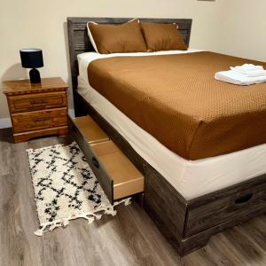 a bedroom with a bed and a nightstand and a bed sidx sidx at Modern Private Suite, Cozy, Stylish & Spacious in Regina