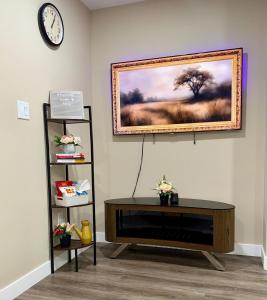 a living room with a table and a picture on the wall at Modern Private Suite, Cozy, Stylish & Spacious in Regina