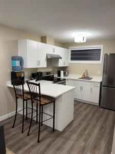 a kitchen with white cabinets and a table and chairs at Modern Private Suite, Cozy, Stylish & Spacious in Regina
