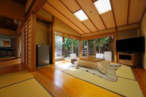 a large living room with a television and a couch at 三平荘 in Atami