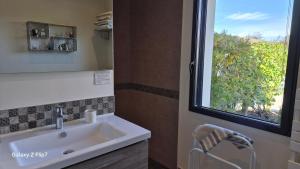 a bathroom with a sink and a window at AU GRAIN D'ORGE in Échiré