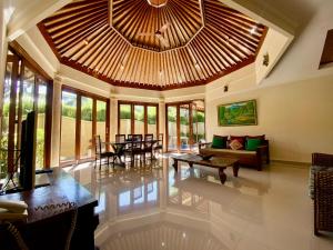 a large living room with a large wooden ceiling at Bali Emerald Villas in Sanur