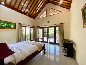 a bedroom with a bed in a room with windows at Bali Emerald Villas in Sanur +95 photos