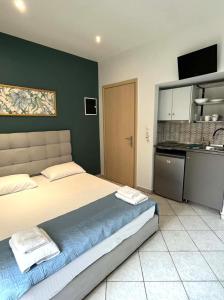 a bedroom with a large bed and a kitchen at Grecian Sea in Limenaria