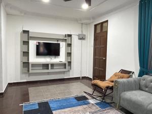 a living room with a couch and a flat screen tv at Zinirah Homestay in Tumpat