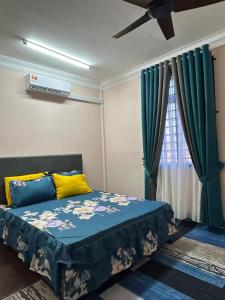 a bedroom with a bed and a window with green curtains at Zinirah Homestay in Tumpat