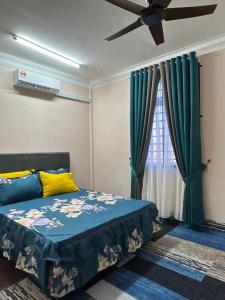 a bedroom with a bed and a ceiling fan at Zinirah Homestay in Tumpat