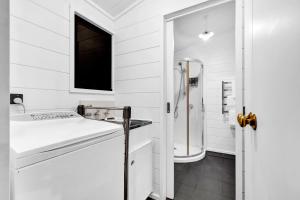 a white bathroom with a sink and a shower at Island view Experience in Coromandel Town +37 photos