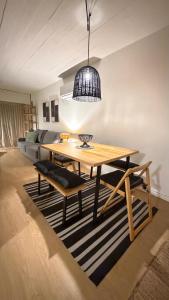 a dining room with a wooden table and a black pendant at Puerta Azul in Punta del Este