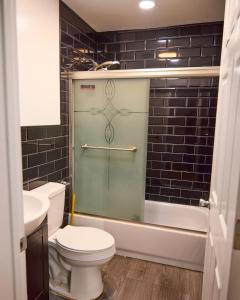 a bathroom with a toilet and a glass shower at SEVENeCOZY in Edgemere