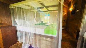 a bedroom with a bed with a white curtain at Elegant Elephant Tree House Sigiiriya in Sigiriya